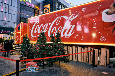small Christmas trees in front of a large Coca Cola truck Image 17