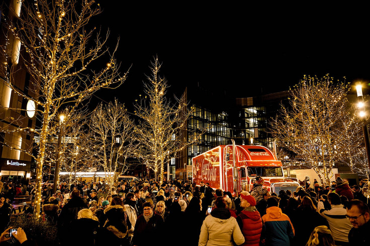 Crowd of people with the Coca-Cola Christmas Truck and bare trees Image 3
