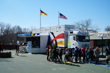 Flag Germany and US with a crowd of people standing in front of the Roadshow truck Image 25