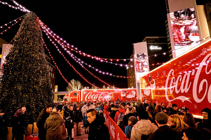 The Coca-Cola Christmas Truck at the christmas market with a crowd of people Image 9